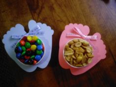 two bowls filled with candy sitting on top of a wooden table