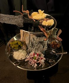 a three tiered tray with different types of food on it, including olives and cheese