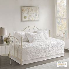 a white daybed in a bedroom next to a window