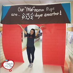 a woman standing under a sign that says our paw some are 3 days smarter on it