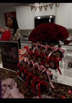 a woman standing in front of a table filled with red roses