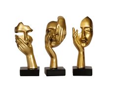 three gold sculptures on black bases with one holding the other's hand up to their face