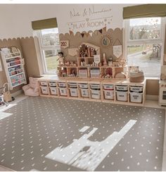 a playroom with lots of toys and storage bins on the floor in front of large windows