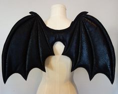 a white mannequin with a black bat costume on it's chest and wings