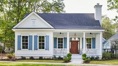 a small white house with blue shutters