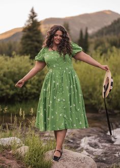 Escape To The Woods This vibrant green dress adorned with a delicate white floral print captures the essence of a sunlit meadow. The dress features a smocked back with a charming button-down front and short puff sleeves for a classic touch. Inspired by nature's beauty, this dress is the perfect choice for a leisurely stroll or special occasion. Functional front buttons Smocked back Elastic sleeves Pockets Recommend sizing up for larger busts Model Details Content + Care 100% Cotton Machine Wash Plus Size Cottagecore Fashion, Plus Size Cottagecore, Floral Plus Size Dresses, Stitch Clothing, Thrift Store Outfits, Cottage Core Dress, Cool Green, Elastic Sleeves, Fashion Capsule Wardrobe