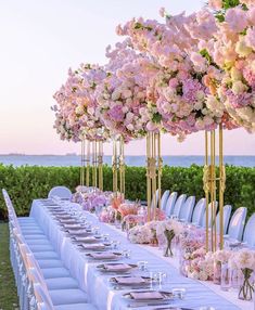 a long table set up with flowers and place settings