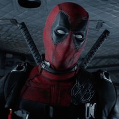 the deadpool character is dressed in red and black with two knives sticking out of his chest