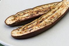 two pieces of eggplant sitting on top of a white plate