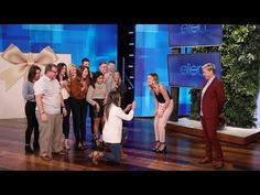 a group of people standing on top of a wooden floor in front of a tv screen