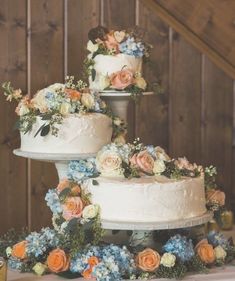 three tiered wedding cake with flowers and greenery