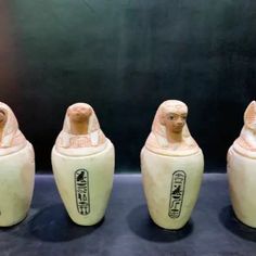 three egyptian style vases sitting next to each other