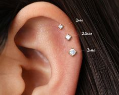 three different types of piercings are shown on the ear and behind it is an image of