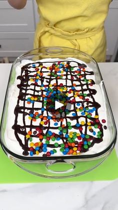 a cake with chocolate icing and sprinkles on it in a glass dish