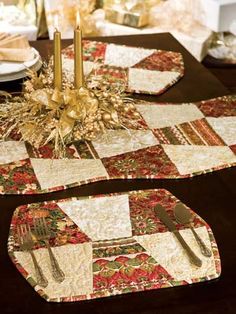 two placemats on a table with silverware and gold candlesticks in the center