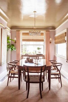 a dinning room table with chairs and a chandelier hanging from the ceiling