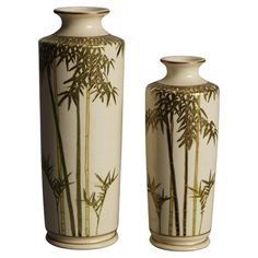 two white vases with bamboo designs on them