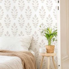 a bedroom with a plant on the side table