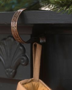 a handbag hanging from the side of a black fireplace with a pine tree in the background