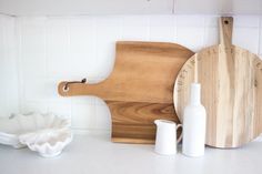 a wooden cutting board sitting on top of a white counter