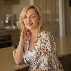 a woman sitting at a kitchen counter with her hand on her face and looking off to the side