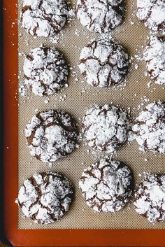 chocolate crinkle cookies on a baking sheet with powdered sugar