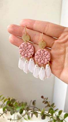 the pink and white flower earrings are hanging from gold hooks