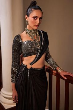 Black pre-draped saree with placement hand embroidery and a show ring placed at the waist. Paired with a blouse with all over hand embroidery using shimmering stones, sequins, beads and cutdana.
Components: 2
Pattern: Hand Embroidery
Type Of Work: Sequins, Stones, Cutdana
Neckline: Sweetheart Neck
Sleeve Type: Full Sleeves
Fabric: Saree: Crepe, Blouse: Dola Silk 
Color: Black
Other Details: 

Note: All the jewellery worn by the model is not for sale
Occasion: Cocktail - Aza Fashions Glamorous Black Pre-draped Saree, Black Pre-draped Saree With Zari Work, Black Glamorous Pre-draped Saree With Zari Work, Glamorous Black Choli With Traditional Drape, Glamorous Black Saree, Glamorous Black Fitted Pre-draped Saree, Glamorous Black Pre-draped Saree In Traditional Style, Glamorous Black Pre-draped Traditional Saree, Glamorous Festive Black Blouse