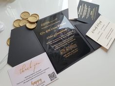 the wedding stationery is laid out on top of the table with some gold coins