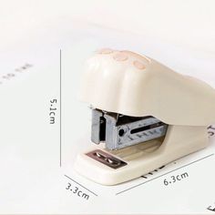 a white stapler sitting on top of a piece of paper