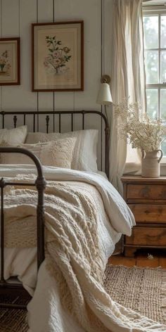 a bedroom with white bedding and pictures on the wall next to the window in it