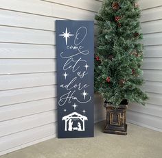 a christmas sign next to a small tree