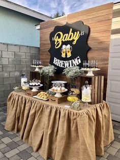 a baby is brewing sign and table with food on it