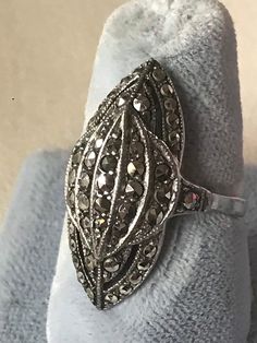 "Gorgeous original antique Art Deco ring in sterling silver with marcasites set in a geometric design. The shape is wonderful. This ring looks fabulous in.. it is an elongated three dimensional dome in a modified marquise shape with geometric detailing. Full of sparkling marcasites which were all the rage with flappers in the Deco era. Marcasite jewels, sometimes known as \"black diamonds\" were the poor girls answer to diamonds but in a lot of ways are more endearing and fascinating, as the Old Vintage Oval Marcasite Rings, Vintage Marcasite Oval Rings, Antique Silver Diamond Ring Collectible, Art Deco Silver Oval Rings, Silver Oval Art Deco Rings, Silver Oval Diamond Ring Collectible, Silver Oval Diamond Ring For Collectors, Victorian Style Silver Oval Diamond Ring, Victorian Style Oval Silver Diamond Ring