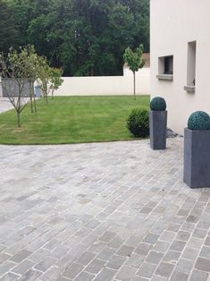 an outdoor area with two large planters on either side of the building and grass in the background