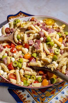 a bowl filled with pasta and vegetables on top of a table