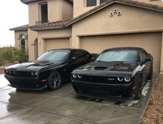 two black cars parked in front of a house