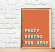 an orange poster with the words fancy seeing you here in blue and yellow on it