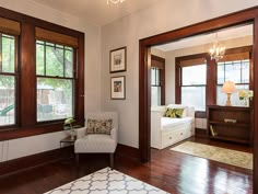 a living room filled with furniture and lots of wood trimming on the windowsill