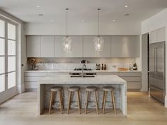 a large kitchen with marble counter tops and bar stools