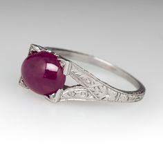 This captivating ring features a pierced and engraved design with milgrain details and is centered with an oval, ruby cabochon, weighing 2.53 carats, in a four-prong setting. The ring measures 7.1mm at the top, rises 7.9mm above the finger, tapering to 1.1mm wide and 0.7mm thick at the base of the shank. This ring is currently a size 5. Engraved Design, Ruby Ring, The Ring, Oval Cut, Prong Setting, Platinum, Ruby, Ring, Design