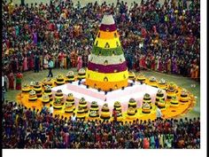 a large group of people standing around a giant cake