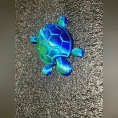 a blue and green turtle laying on the ground