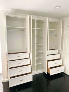 an empty walk in closet with white drawers