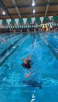 a person swimming in a pool with people watching