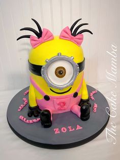 a yellow and pink cake with a minion on top