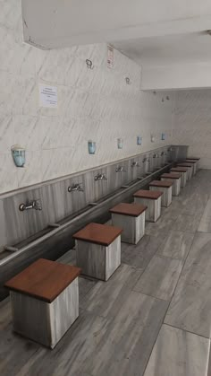 a row of benches sitting next to each other on top of a tiled floor in a building