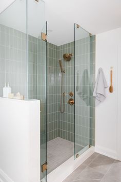 a walk in shower sitting next to a white sink under a faucet mounted on a wall