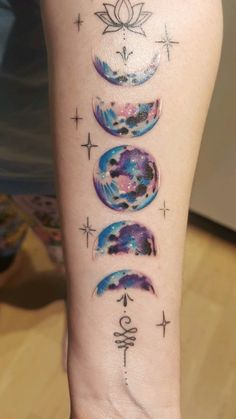 a woman's leg with tattoos on her legs and the phases of planets in different colors