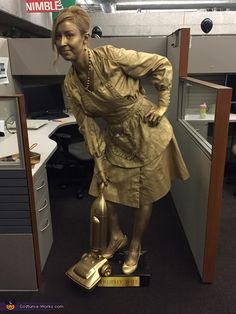 a woman in an office cubicle with a gold statue